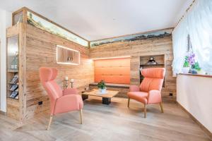 a living room with two chairs and a table at Haus zur Vogelweide App 6 in Dobbiaco