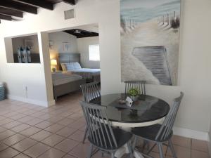 a dining room with a table and chairs and a bedroom at Sands of Islamorada in Islamorada