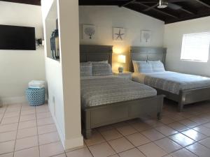 a bedroom with two beds and a flat screen tv at Sands of Islamorada in Islamorada