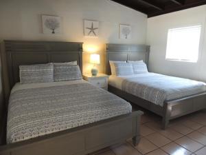 1 dormitorio con 2 camas y ventana en Sands of Islamorada, en Islamorada