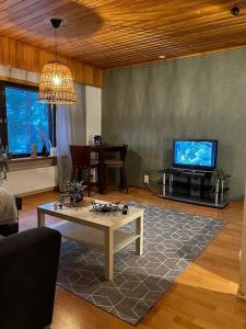 a living room with a table and a tv at Tilava huoneisto in Saarijärvi