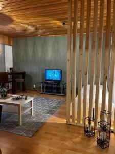 a living room with a tv and a table at Tilava huoneisto in Saarijärvi