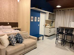 a living room with a couch and a kitchen at Loft Solar Água in Pipa