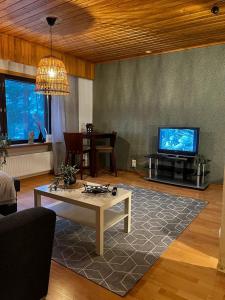 a living room with a table and a tv at Tilava huoneisto in Saarijärvi