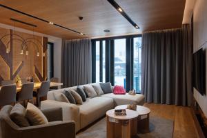 - un salon avec un canapé et une table dans l'établissement Galeria Jahorina Luxury Ski Apartments and Restaurant, à Jahorina