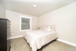 a white bedroom with a bed and a window at Delightful, new townhome downtown in Billings