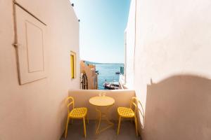 un tavolo e sedie in un balcone con vista sull'oceano di Anelia House a Oia