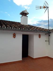 un edificio blanco con techo y satélite en Casa Rural La Maestra, en Atajate
