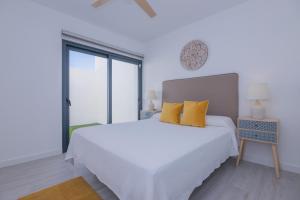 a white bedroom with a large white bed with yellow pillows at Villa Casilla de Costa Private Pool Luxury La Oliva By Holidays Home in La Oliva