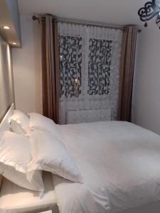 a bed with white sheets and pillows in a room at Apartament Central in Oradea