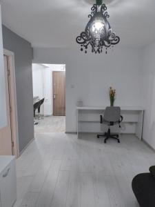 an empty room with a desk and a chandelier at Apartament Central in Oradea +5 photos