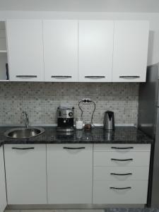 a kitchen with white cabinets and a toaster on a counter at Apartament Central in Oradea