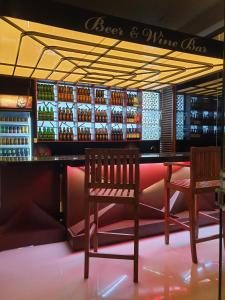 un bar con 2 sillas y una barra con botellas de vino en Delhousie Hotel, en Nallathanniya