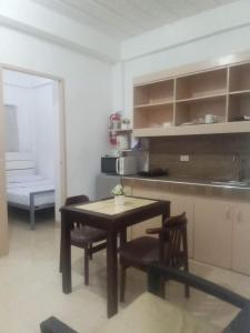 uma cozinha com mesa e cadeiras num quarto em Kendall Place Apartment em Cagayan de Oro