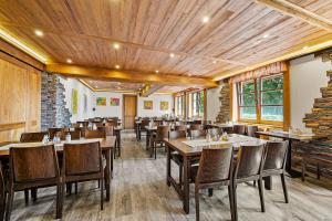 a dining room with wooden ceilings and tables and chairs at David Wellness Hotel in Harrachov