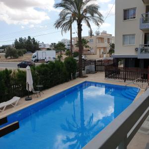 a large blue swimming pool next to a building at LINA'S HOME & POOL - Breakbooking CY in Laxia