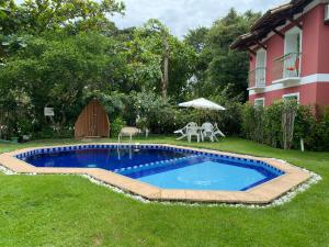 uma piscina num quintal ao lado de uma casa em Flores da Aldeia em Arraial d'Ajuda