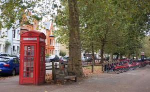 a red phone booth next to a row of parked bikes at Luxury Chelsea Apartment in London +2 photos