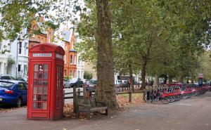 una cabina telefónica roja junto a una fila de bicicletas estacionadas en Luxury Chelsea Flat, en Londres