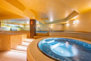 a jacuzzi tub in a room with stairs at David Wellness Hotel in Harrachov