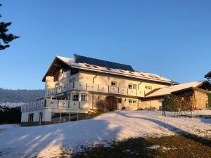 a building with solar panels on it in the snow at Hotel "Haus am Berg" in Rinchnach