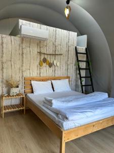 1 dormitorio con 1 cama grande y escalera en EvergreenGlamping en Kumluca