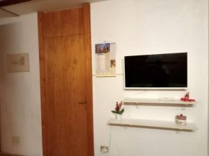 Zimmer mit einem Flachbild-TV an der Wand in der Unterkunft TERRAZZA SULLE DOLOMITI in Castello di Fiemme