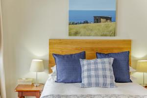 1 dormitorio con 1 cama con almohadas azules y blancas en The Ashford, en Johannesburgo