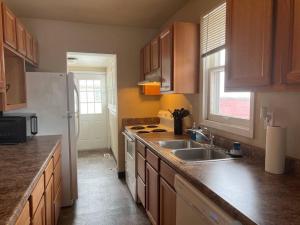 eine Küche mit Holzschränken, einer Spüle und einem Kühlschrank in der Unterkunft Classic home on a quiet street in Billings