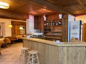 a bar in a restaurant with two stools at Dolomites Hotel La Meridiana in Moena