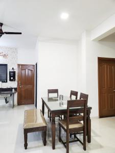 - une salle à manger avec une table, des chaises et un piano dans l'établissement VedGanga Plus Villa - Homestay, à Kolhapur