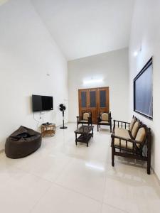 d'un salon avec des chaises et une télévision à écran plat. dans l'établissement VedGanga Plus Villa - Homestay, à Kolhapur