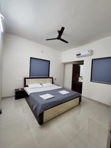 a bedroom with a bed and a ceiling fan at VedGanga Plus Villa - Homestay in Kolhapur