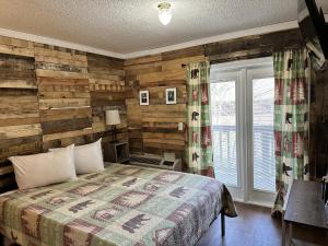 a bedroom with a bed and a wooden wall at Ski Mountain Lodge in Gatlinburg