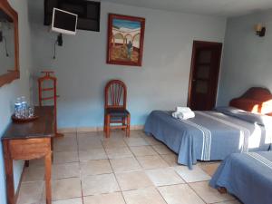 a bedroom with a bed and a desk and a chair at posada San Alejandro in Pátzcuaro