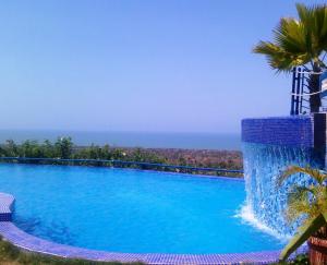 een zwembad met de oceaan op de achtergrond bij Hotel Eco Inn Jose in Puerto Píritu