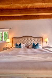 a large white bed with two blue pillows on it at Château Salavaux in Salavaux