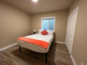 a bedroom with a bed with a red blanket on it at Freshly renovated home in a vintage neighborhood in Billings