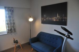 a living room with a blue couch and a lamp at at Number 1 in Rumst