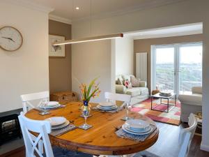 a dining room table with chairs and a clock on the wall at Fell View - Dog-Friendly House, Enclosed Garden & Great Views in Penrith