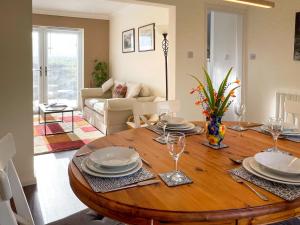 a dining room with a wooden table with plates and wine glasses at Fell View - Dog-Friendly House, Enclosed Garden & Great Views in Penrith