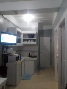 een witte keuken met een wastafel en een magnetron bij Kendall place Apartments in Cagayan de Oro