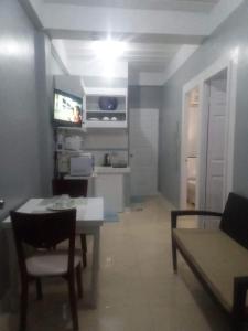 een woonkamer met een tafel en een keuken met een tv bij Kendall place Apartments in Cagayan de Oro