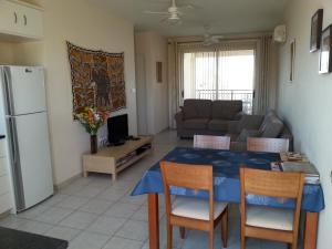 een keuken en een woonkamer met een tafel en stoelen bij Royal Seacrest in Paphos City