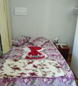 - un lit avec une couverture et une robe dans l'établissement Pousada Seu Jorge, à Campinas