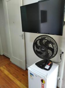 a flat screen tv on top of a white refrigerator at Pousada Seu Jorge in Campinas