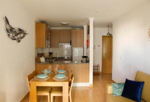 a kitchen and dining room with a table and chairs at Monte da Praia in Monte Gordo