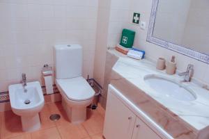 bagno con servizi igienici, lavandino e specchio di Monte da Praia a Monte Gordo
