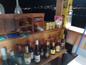 una fila de botellas de vino sentadas en un estante en Faera Hostel, en Darién