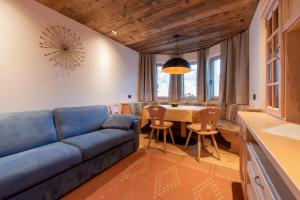 a living room with a blue couch and a table at Apartments Ciasa Costisela in San Vigilio Di Marebbe